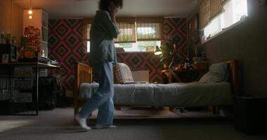 A person walking in a room with a bed and a desk video