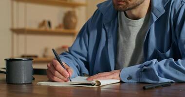 A man is writing in a notebook video
