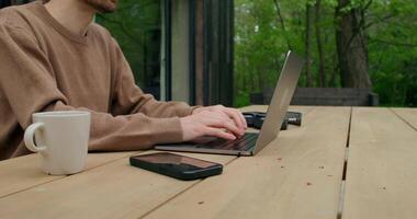 A man sitting at a table with a laptop and a cup of coffee video