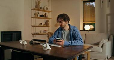 A man sitting at a table with a cup of coffee and a phone video