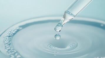 Pipette dropping serum into water creating ripples and bubbles photo