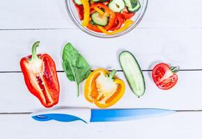 Process of cutting vegetables on wooden table for salad photo