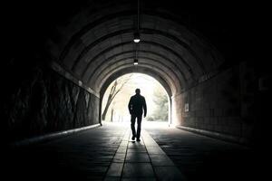 Man walking towards light at end of tunnel symbolizing hope and new beginnings photo