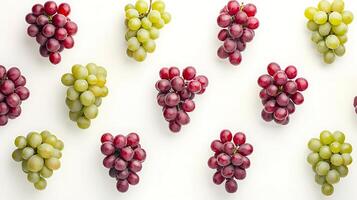 Bunches of green and red grapes forming a pattern on white background photo