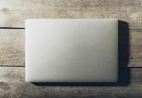 Top view of laptop on grunge wooden background photo