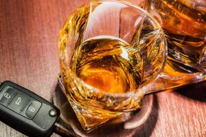 Drunk driving concept. Glass of alcohol drink and car keys photo