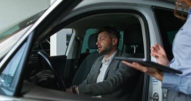 A man and woman in a car talking on a tablet video