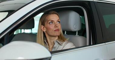 A woman is looking out the window of a car video