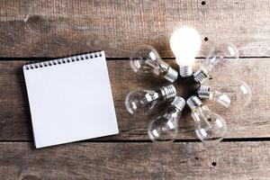 Lightbulb and blank open notepad. Having an idea concept photo