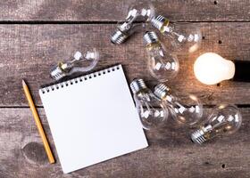 Lightbulb and blank open notepad. Having an idea concept photo