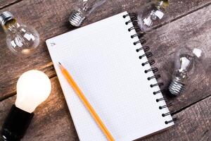 Lightbulb and blank open notepad. Having an idea concept photo