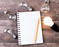 Lightbulb and blank open notepad. Having an idea concept photo
