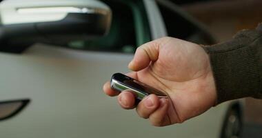A person holding a remote control in front of a car video