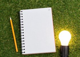 Lightbulb and blank open notepad. Having an idea concept photo