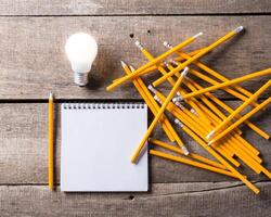 Lightbulb and blank open notepad. Having an idea concept photo