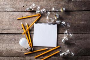 Lightbulb and blank open notepad. Having an idea concept photo