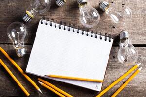 Lightbulb and blank open notepad. Having an idea concept photo