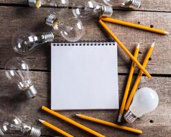 Lightbulb and blank open notepad. Having an idea concept photo