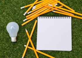 Lightbulb and blank open notepad. Having an idea concept photo