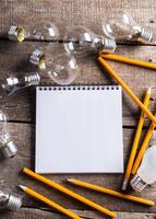 Lightbulb and blank open notepad. Having an idea concept photo