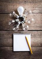 Lightbulb and blank open notepad. Having an idea concept photo