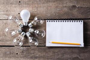 Lightbulb and blank open notepad. Having an idea concept photo