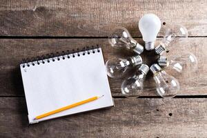 Lightbulb and blank open notepad. Having an idea concept photo