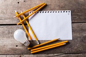 Lightbulb and blank open notepad. Having an idea concept photo