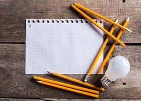Lightbulb and blank open notepad. Having an idea concept photo