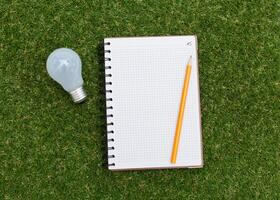 Lightbulb and blank open notepad. Having an idea concept photo