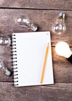 Lightbulb and blank open notepad. Having an idea concept photo