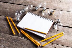 Lightbulb and blank open notepad. Having an idea concept photo