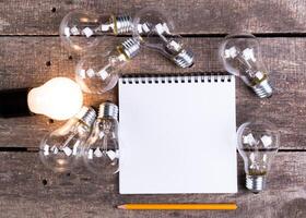 Lightbulb and blank open notepad. Having an idea concept photo