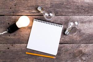 Lightbulb and blank open notepad. Having an idea concept photo