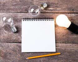 Lightbulb and blank open notepad. Having an idea concept photo