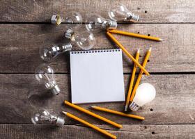 Lightbulb and blank open notepad. Having an idea concept photo