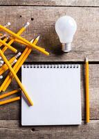 Lightbulb and blank open notepad. Having an idea concept photo