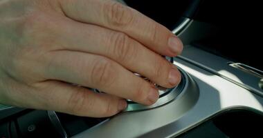 A person's hand is pressing a button on a car's gear stick video