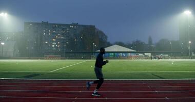 A man is running on a track at night video