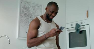 A man in a tank top is using his cell phone video