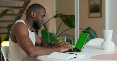 A man sitting at a table with a laptop computer video