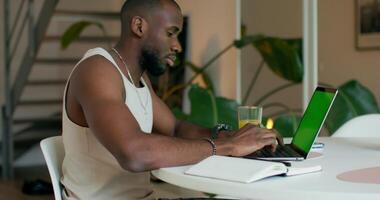 A man sitting at a table with a laptop computer video