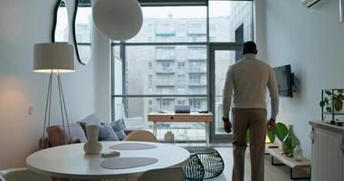 A man is standing in a living room with a table and chairs video