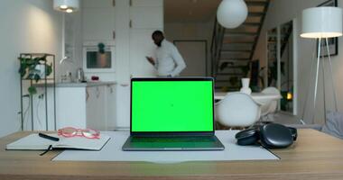 A laptop with a green screen on a desk video