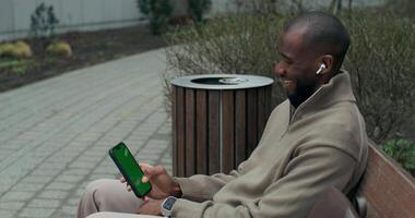 A man sitting on a bench with a tablet computer video