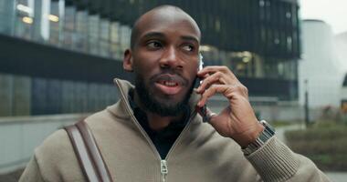 A man talking on a cell phone in front of a building video