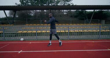 A man is running on a track with a soccer ball video