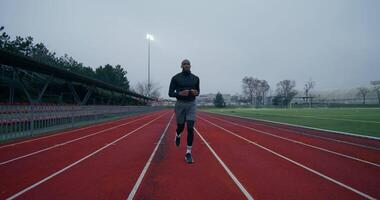 A man running on a track in a stadium video