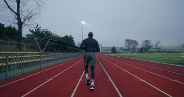 A man running on a track in a stadium video