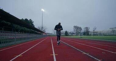 A man is running on a track in a stadium video